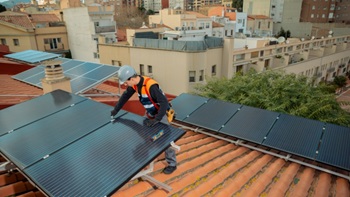 Pannelli fotovoltaici con operaio su un tetto